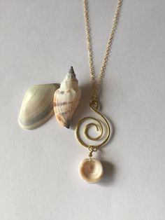 Genuine Hawaiian Puka Shell gold plated spiral wire necklace set on an 18 inch gold plated chain finished with a gold plated lobster clasp. The gold plated chain is nickel free. This beautiful and rare Hawaiian Puka shell was hand picked from the beaches of Hawaii. It makes a great Gold Spiral Jewelry For The Beach, Elegant Spiral Beach Jewelry, Handmade Spiral Necklaces For Beach, Spiral Wire Wrapped Jewelry For Beach, Adjustable Spiral Jewelry For Beach, Spiral Brass Necklace For Gift, Gold Round Pendant Necklace For Beach, Gold Shell Charm Necklace For Beach, Gold Wire Wrapped Shell Necklace