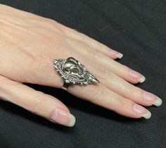 "This richly detailed antiqued silver ring is accented with a raven skull, set in a lovely frame. It measures 1 1/2\" tall and 1\" wide. Ring is adjustable hypoallergenic stainless steel. Matching earrings and pendant are listed in our store." Collectible Silver Gothic Skull Ring, Antique Silver Skull Ring Gift, Antique Silver Skull Ring As Gift, Collectible Gothic Silver Skull Ring, Silver Gothic Skull Ring Collectible, Silver Gothic Skull Ring, Collectible, Antique Silver Skull Ring For Gift, Nickel-free Silver Gothic Skull Ring, Skull Cameo