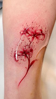 a woman's thigh with red flowers on it and white thread in the middle