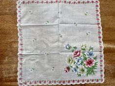 "An beautiful vintage floral handkerchief. It has a white, sheer base with white, blue and green flowers all over, and yellow, green, blue, and pink flowers in the corner. It also has white, scalloped trimming on the edges. Perfect for using as a quilt square for a quilt. It measures 14 1/2\" by 14 1/2\". It is in great vintage condition with no rips, tears or holes. Unused. Please come visit our shop to view our entire vintage selection at GoosesTreasureShop- https://www.etsy.com/shop/GoosesTre White Handkerchiefs As Spring Gifts, White Handkerchiefs For Spring Gifts, Spring Gift White Handkerchiefs, Vintage Cotton Handkerchiefs For Spring, White Cotton Handkerchiefs For Spring, Vintage Flower Shaped Handkerchiefs For Spring, Vintage Flower Handkerchiefs For Spring, Vintage Flower-shaped Handkerchiefs For Spring, Spring Vintage Flower Shaped Handkerchiefs