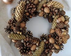 a christmas wreath with pine cones and ornaments