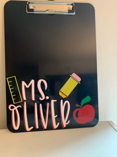 a clipboard with the words mrs olive written on it and an apple next to it