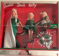 three dolls dressed in green and white are sitting on the stairs with christmas decorations around them