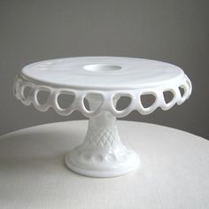 a white cake plate sitting on top of a table