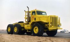 a large yellow truck driving down a road