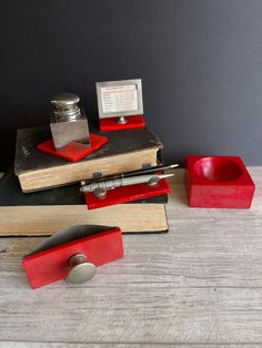 a stack of books sitting on top of a wooden table next to a red cup