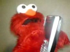 an elmo holding a cell phone up to its face