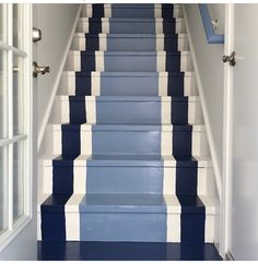 blue and white painted stairs leading up to an open door on the second floor in a home