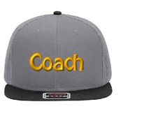 a gray and black hat with the word coach written on it in gold letters, against a white background