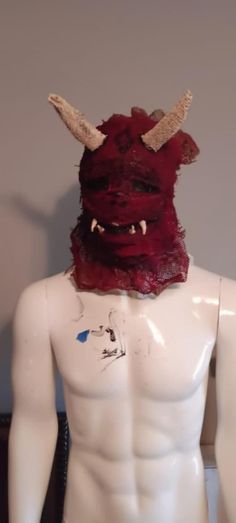 a white male mannequin with red hair and horns on it's head