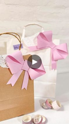 a bag with pink bows on it next to some baby shoes