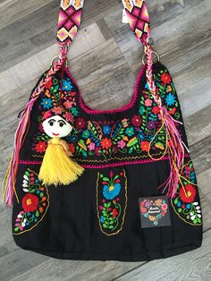 "This is a beautiful, embroidered bag handmade by Mexican Artisans With elegant multi-colored designs and patterns Each embroidered bag takes about 10 hours to make Straps are made with macrame technic The strap is long enough to wear as a simple over the shoulder or as a crossbody Excellent gift for any occasion ** Tassel sold separately Due to the handmade nature of this item the embroidered colors and patterns may vary  **HAND WASH ONLY** Follow and tag us on Instagram @mardiaartesanal MEASUREMENTS Body 16\" X 13\" Strap 16\"" Black Embroidered Hobo Tote Bag, Multicolor Floral Embroidered Shoulder Bag For Travel, Multicolor Floral Embroidery Shoulder Bag For Travel, Traditional Handmade Multicolor Hobo Bag, Rectangular Bag With Multicolor Embroidery And Hand-stitched Details, Hand-stitched Rectangular Bag With Multicolor Embroidery, Handmade Multicolor Embroidered Hobo Bag For Everyday Use, Handmade Multicolor Embroidery Hobo Bag For Everyday Use, Bohemian Bag With Floral Embroidery As Gift