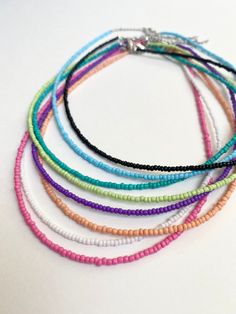 These necklaces are handmade with flexible nylon coated stainless steel beading wire, stainless steel lobster clasps, 2 mm seed beads and a 2.5 inch stainless steel extender chain for the perfect fit. Perfect for every day, any occasion, or even a gift! Choker length: 14 inches Extender chain length: 2.5 inches Choose which choker you would like by selecting the color name above the choker you want in picture 10. Please make sure the length of each choker will work for you. If you have a custom Minimalist Tiny Beads Choker For Summer, Minimalist Beaded Necklaces With Colorful Beads For Summer, Minimalist Tiny Beads Necklace For Summer, Minimalist Summer Beaded Necklace With Tiny Beads, Summer Minimalist Beaded Necklace With Tiny Beads, 2mm Seed Bead Necklace, Minimalist Tiny Beads Choker Necklace, Minimalist Choker With Tiny Beads, Dainty Choker With Tiny Round Beads