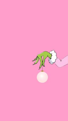 a hand reaching for something on top of a white ball in the air with pink background