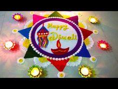 happy diwali greeting card with candles and colorful decoration on the floor in front of it