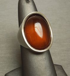 "Vintage Circa 1970 in a Euro Art Deco Style Constructed of Sterling Silver with 1 Oval shaped piece of Natural Amber Top section of ring measuring approximately 1\" in length & about 9.9mm high when on the finger Stamped: 925 Additional photos/details upon request. Finger Size 7.5 *Sizing upon request (Sizing down runs about $25.. Sizing up starts at $45) Weighing 11.4 grams *Sale of ring includes an appraisal certificate for your insurance purposes. All pieces shipped insured via USPS Prio Modernist Formal Cabochon Rings, Mid-century Polished Finish Jewelry For Anniversary, Vintage Brown Ring With Polished Finish, Vintage Concave Jewelry With Polished Finish, Retro Polished Rings For Formal Events, Retro Formal Rings With Polished Finish, Vintage Open Ring With Polished Finish, Retro Rings With Polished Finish For Formal Occasions, Brown Hallmarked Vintage Ring