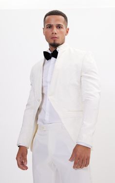 DETAILS This white tailored fit tuxedo is a unique and stylish option for any special or formal event. Features a raised laced texture of the fabric that creates depth and dimension, adding a tactile element to the jacket. Designed with a mandarin collar. which adds a touch of modernity to the jacket. As well as having a satin finish around the closure, giving a luxurious sheen to the outfit. Pair with any Tomson Tuxedo Pants SIZE + FIT Tailored fit, to find your correct size use the ''What's my Luxury White Suit For Evening, Luxury White Evening Suit, Elegant Semi-formal Spring Tuxedo, Elegant Spring Semi-formal Tuxedo, Luxury White Evening Tuxedo, Elegant Spring Ceremony Suits, White Tuxedo Blazer For Evening, Elegant Tailored White Tuxedo, White Fitted Tuxedo With Notch Lapel