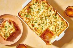 a casserole on a plate with a fork next to it and two glasses