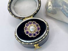 A Beautiful Old 9 karat Gold, Pearl & Purple Amethyst Flower Cluster Halo Ring. A beautiful quality early English made fine gemstone ring circa 1940 - 1960. Hallmarks: 'J&J' English maker circa 1890- 1960 '375' for 9 karat yellow Gold and London assay office marked.  This beautiful antique ring is Victorian style and was fashioned as a classic Edwardian statement jewel. The ring has a central snow white freshwater pearl (drilled to the back) surrounded by 10 flush-set round cut mid purple amethy Antique Amethyst Birthstone Ring, Victorian Style Amethyst Ring Stamped 14k, Victorian Style 14k Stamped Amethyst Ring Gift, 14k Stamped Amethyst Wedding Ring, Flower Halo Engagement Ring, Pearl Purple, Amethyst Flower, Nature Inspired Engagement Ring, Flower Halo