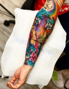 a person with a colorful tiger tattoo on their arm and hand, holding onto a white towel