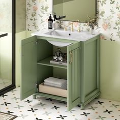 a green cabinet with a sink and mirror in a small bathroom, next to a floral wallpapered wall