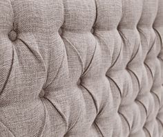 a close up view of the back of a bed with pleated fabric on it