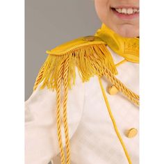 a young boy wearing a yellow and white uniform with fringes on it's shoulders