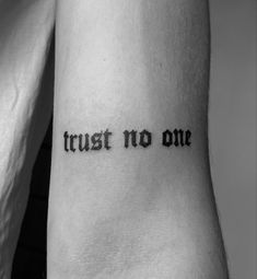 a tattoo that says trust no one on it