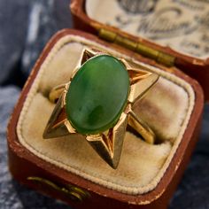 This fantastic retro 1950s ring features a centered oval cabochon cut nephrite jade.  The ring has gorgeous angles and patinated gold work for a simple but bold design.  The ring is crafted in 9k yellow gold and is currently a size 7.25. Vintage 14k Gold Emerald Oval Cabochon Ring, Vintage Green Signet Ring With Gemstone, Vintage 14k Gold Oval Cabochon Emerald Ring, Retro Oval Cabochon Jewelry, Vintage Green Gemstone Signet Ring, Vintage Polished Emerald Ring With Oval Cabochon, Vintage Emerald Oval Cabochon Ring With Polished Finish, Vintage Oval Cabochon Emerald Ring With Polished Finish, Vintage Emerald Cabochon Ring Collectible