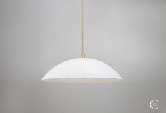 a white and gold light hanging from a ceiling