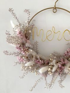 a wreath with flowers and the word merci hanging from it's front door