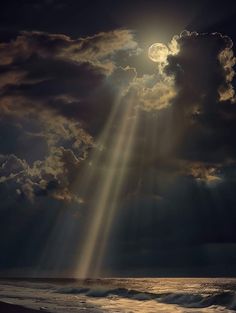 the sun is shining through clouds over the ocean