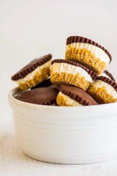 a bowl filled with chocolate covered desserts on top of a white countertop next to a fork