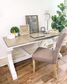 a desk with a chair, lamp and potted plant on it in a home office