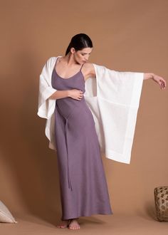 a woman in a purple dress is holding a white shawl over her shoulder and looking down