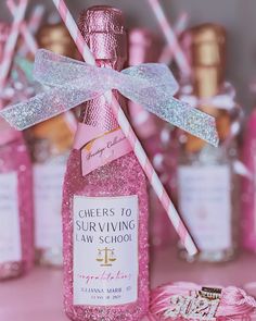 a pink bottle filled with candy canes on top of a table next to other bottles