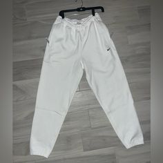 Elevate Your Activewear Game With These Nike Sportswear Solo Swoosh Fleece White Sweatpants For Men. The Cozy Fleece Fabric Will Keep You Warm During Your Workouts, While The Stylish Design Makes Them Perfect For Casual Wear Too. The Nike Brand Name Speaks For Itself In Terms Of Quality, And The Sweatpants Come In Size S, Perfect For A Regular Fit On Men. These Sweatpants Are Ideal For Any Occasion, Whether It Be A Morning Jog Or A Casual Day Out. The White Color And Swoosh Logo On The Side Give White Sweatpants With Elastic Waistband For Sports, Nike Sporty Sweatpants For Sports Season, Sporty White Sweatpants With Elastic Waistband, White Sweatpants With Elastic Waistband For Jogging, White Sweatpants With Elastic Waistband, White Jogging Bottoms For Sports Season, White Sweatpants With Ribbed Waistband For Sports, White Sweats With Elastic Waistband For Streetwear, White Sports Joggers With Elastic Waistband