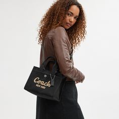 Carry as much (or as little) as you like with our lightweight Cargo tote. Detailed with our cursive Coach script embroidery and iconic turnlock closure this compact 26 has an open interior with room for an iPad two outside pockets for easy organization and a removable webbing strap for shoulder or crossbody wear. Crafted to last this versatile carryall is made with cotton sourced from farms that use regenerative agricultural practices* and inspired by our commitment to reducing our impact on the Small Coach Bag, Script Embroidery, Coach Tote Bag, Agricultural Practices, Coach Tote Bags, Coach New York, Coach Tote, Small Tote Bag, Large Wallet