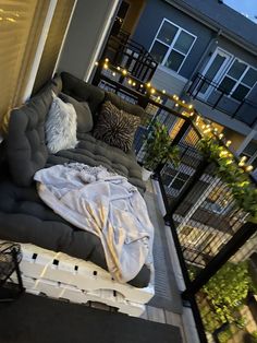 a couch sitting on top of a wooden floor next to a balcony covered in lights