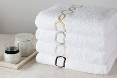 a stack of white towels sitting on top of a table next to a jar of jam