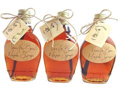 three bottles of maple syrup tied with twine and paper tags, each containing their own name