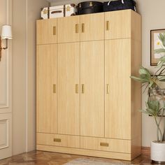 a large wooden cabinet sitting next to a potted plant in a living room on top of a hard wood floor