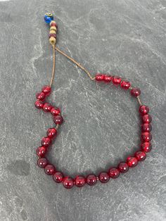 A wonderful set of red glass worry/komboloi beads set on a gold tone chain, with the end beads having gold metal spacers with a larger blue glass stone at the end. In great condition they measure just over 10.5 inches long. Worry beads or komboloi/kompoloi is a string of beads manipulated with one or two hands and used to pass time in Greek and Cypriot culture. Unlike the similar prayer beads used in many religious traditions, worry beads have no religious or ceremonial purpose. Cypriot Culture, Worry Beads, Prayer Beads, Red Glass, Blue Glass, Bead Charms, Gold Metal, The End, Glass Beads