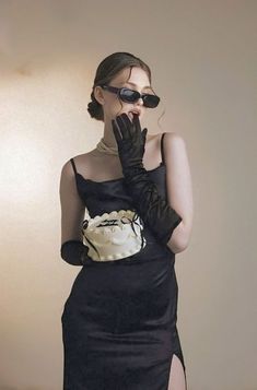 a woman in a black dress and gloves