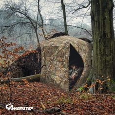 a man is sitting in a camouflaged out shelter