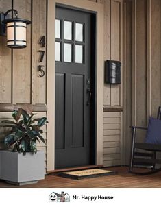 the front door of a house with a rocking chair and potted plant next to it