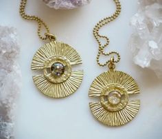 The Meg ~ Brass Medallion Pendant Necklaces feature a brass sunshine shape in raw brass with crushed mother of pearl and gold leaf flake embedded. Hangs on an 18" 20 or 24" brass ball chain. Details • Made in United States • Weight: 0 oz (0 g) • Dimensions: 1.5 x 1.5 x 18 in (3.8 x 3.8 x 45.7 cm) WHO IS CAMEOKO Camille Kohler is the sole artist and maker of cameoko jewelry that is a resin jewelry line that combines resin with crushed gemstones, metallic flakes, pigments for color and more. The l Artisan Gold Etched Jewelry, One Of A Kind Brass Medallion Jewelry, Artisan Etched Gold Jewelry, Spiritual Brass Hammered Necklace, Spiritual Hammered Brass Necklace, Artisan Brass Necklace With Round Pendant, Gold Electroformed Round Jewelry, Artisan Gold Brass Necklace, Artisan Brass Round Pendant Necklace