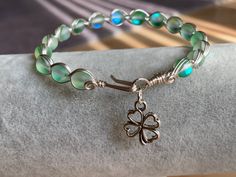 "Celebrate your Irish heritage or St. Patrick's Day! You will have the accessories! Beautiful green Mermaid glass wire wrapped bracelet with four leaf clover charm. 6mm Mermaid Glass beads woven into an Egyptian style bracelet. The wire is silver plated wire with anti tarnish coating. Four leaf clover accent for good luck and a festive appearance. Bracelet is approximately 7.5 inches in length. Different lengths can be requested. Please message seller. Have you ever heard of \"Mermaid Glass\"??? Nickel-free Green Beaded Bracelets As A Gift, Nickel-free Green Beaded Bracelets For Gift, Nickel-free Green Beaded Bracelet For Gift, Green Nickel-free Beaded Bracelets As A Gift, Green Nickel-free Bracelets For Gifts, Nickel-free Green Beaded Bracelets, Nickel Free Glass Bracelets For Gifts, Nickel-free Glass Bracelets As Gifts, Nickel-free Glass Bracelets For Gifts