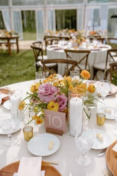 the table is set with flowers, candles and napkins for an elegant dinner party