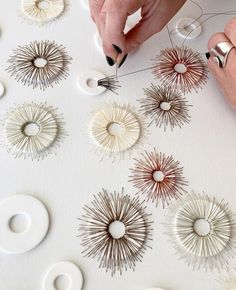 a person is working on some art work with scissors and wire spools in the shape of sunbursts